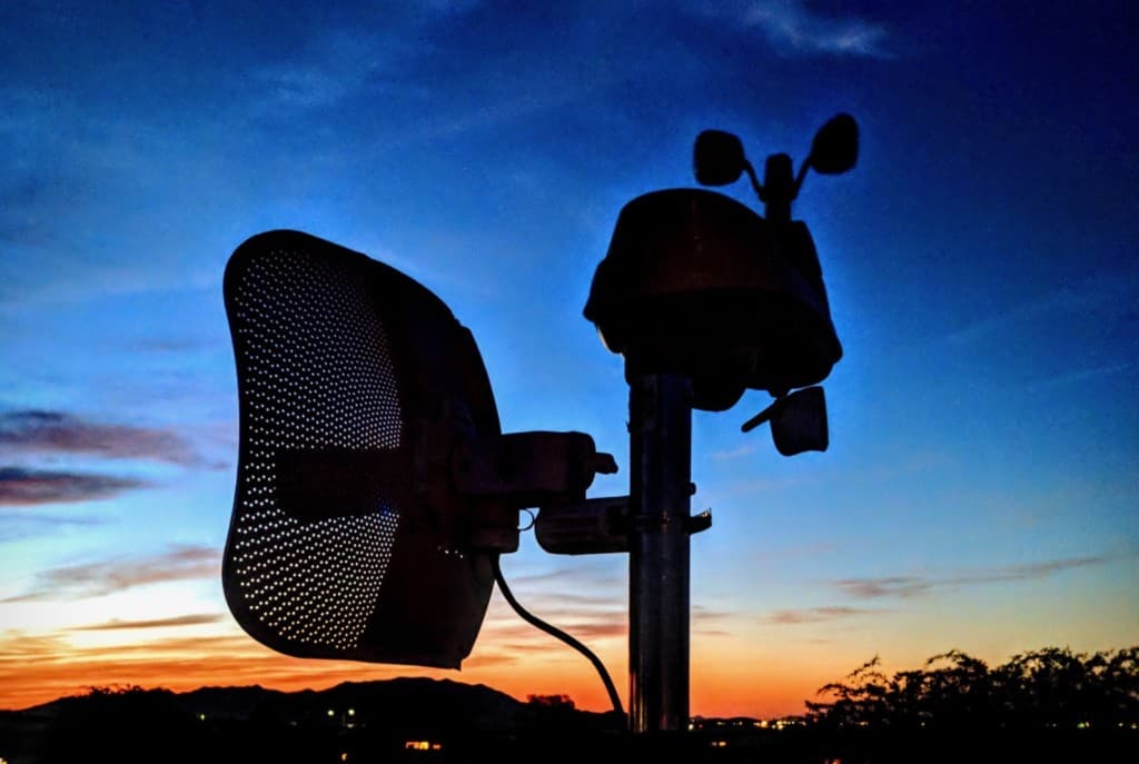 Antena de malla y estación meteorológica al atardecer